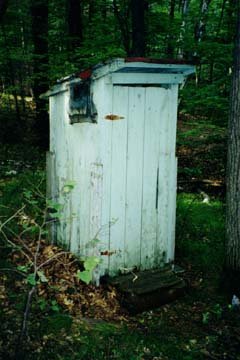 The old outhouse with the door closed