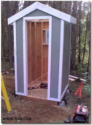 Outhouse mounted on pilings